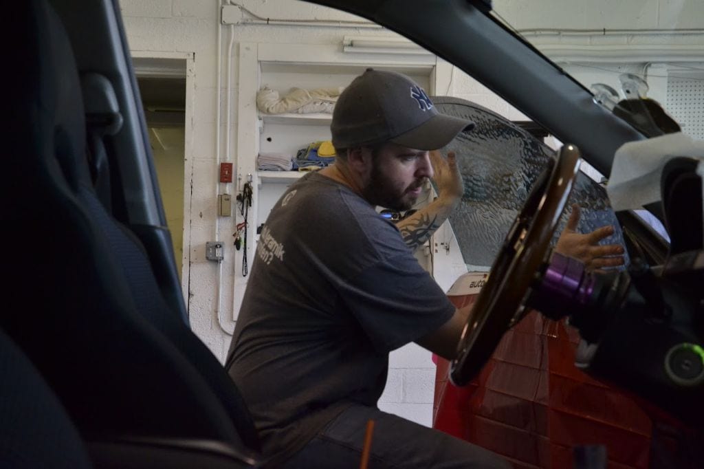 Automotive window tinting being installed on a frameless window